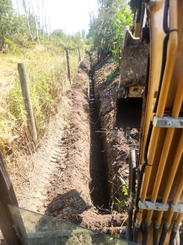 Cab view of a utility trench being dug for service lines in the Okanagan